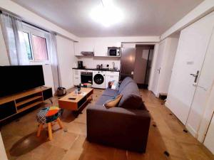 a living room with a couch and a tv at L'Eiffel - Self Checking, 20min from Paris in Drancy