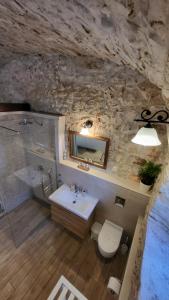e bagno con lavandino, servizi igienici e vasca. di Stone House Apartments Didini Dvori Lumbarda a Lumbarda (Lombarda)
