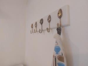 a group of spoons hanging from a hook on a wall at Graslandhof in Neumarkt in Steiermark
