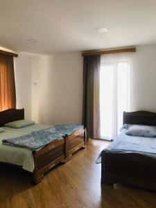 um quarto com 2 camas e uma grande janela em Zviad Guest House em Borjomi