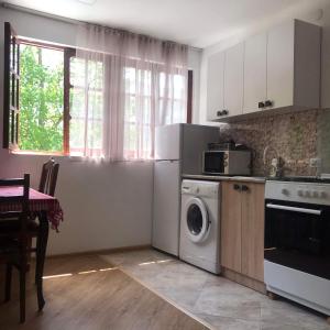 cocina con lavadora y mesa en Zviad Guest House, en Borjomi