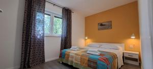 ein Schlafzimmer mit einem Bett und einem Fenster in der Unterkunft Villa HAUS NIKO in Senj