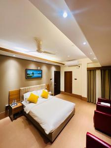 una camera da letto con un grande letto con cuscini gialli di Taj Metro a Maulvi Bāzār