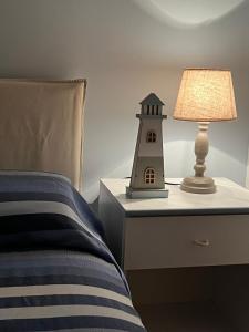 eine Lampe auf einem Nachttisch neben einem Bett in der Unterkunft Villa Zefiro - Campomarino di Maruggio in Campomarino