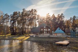 a house by the water with a dock in front of it at Lakeside Escape in Suniši