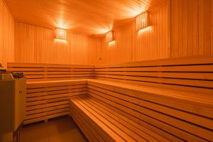 a sauna with wood paneling and lights at Lakeside Escape in Suniši
