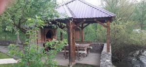 a wooden gazebo with a picnic table and a table at Apartman Vrbas in Jajce