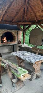 a picnic table in front of a brick oven at Apartman Vrbas in Jajce