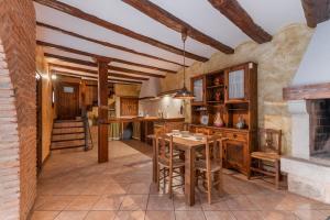 a kitchen with a table and chairs and a fireplace at Casa Rural La Carretería in Camañas