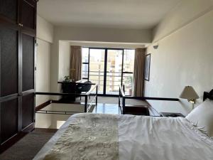 a bedroom with a bed and a room with a balcony at Cómodo duplex en centro de Miraflores in Lima