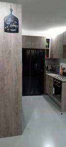 a kitchen with a black refrigerator and a counter at Zachi Apartments in Kitwe