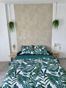 a bedroom with a bed with a green and white comforter at Le Havre de Sérénité - Orly - Gare - Parking privé in Athis-Mons
