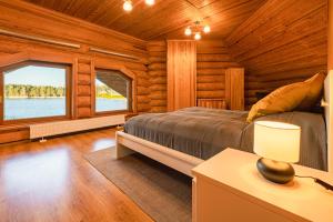 a bedroom with a bed and a window in a log cabin at Lakeside Escape in Suniši