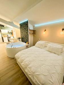 a bedroom with a large bed and a bath tub at Lovicéa Balnéo Suite, 200m plage in Le Grau-dʼAgde