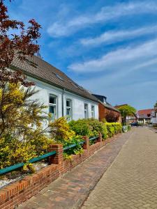 a house with a row of benches on a street at Altes Zollhaus in Borkum