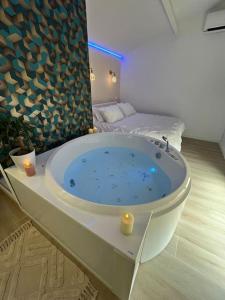 a bath tub in a room with a bed at Lovicéa Balnéo Suite, 200m plage in Le Grau-dʼAgde