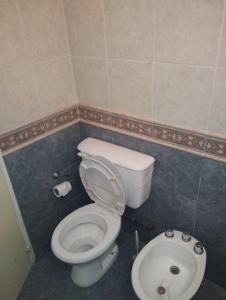 La salle de bains est pourvue de toilettes blanches et d'un lavabo. dans l'établissement JMC, à Jesús María