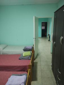 a room with two beds and a hallway with a door at JMC in Jesús María