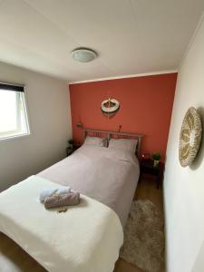 a bedroom with two beds and a red wall at Woodz Aan de bosrand in Anloo