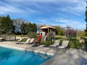 een zwembad met stoelen en een speeltuin bij Coulonges in Savignac-sur-Leyze