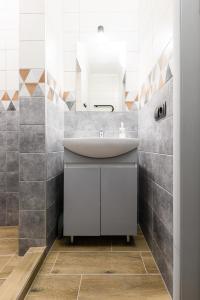 W łazience znajduje się umywalka i lustro. w obiekcie Нові затишні smart-квартири LеГо w mieście Użhorod