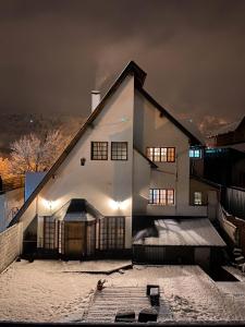 a white house in the snow at night at Bike Hostel in San Martín de los Andes