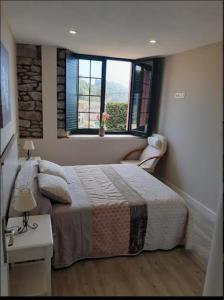 1 dormitorio con cama, mesa y ventana en Mirador del Cantábrico, en Lastres