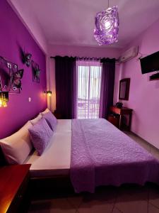 a purple bedroom with a large bed with purple walls at Bella Vista in Bali