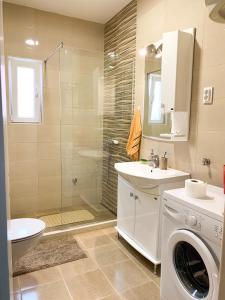 a bathroom with a washing machine and a shower at Talija Apartments in Bijela