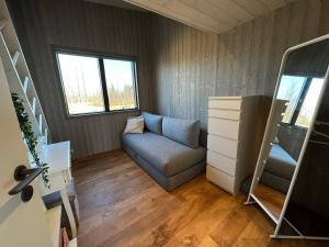 ein kleines Wohnzimmer mit einem Sofa und einer Treppe in der Unterkunft Luxury and Modern Cabin on the Golden Circle in Miðdalur