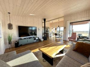 a living room with a couch and a tv and a table at Luxury and Modern Cabin on the Golden Circle in Miðdalur