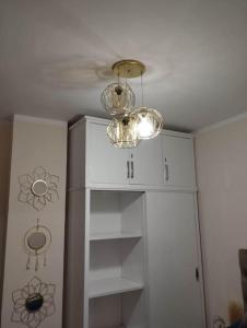 a room with a white cabinet and a chandelier at Úplně nový apartmán v Tropical resort in Hurghada