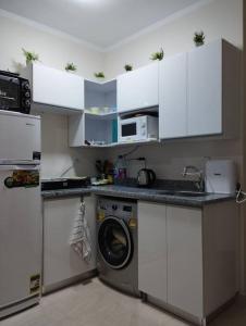 a kitchen with a washing machine and white cabinets at Úplně nový apartmán v Tropical resort in Hurghada