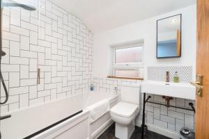 a bathroom with a tub and a toilet and a sink at Modern Maisonette in Vibrant Bristol, Free Parking in Bristol