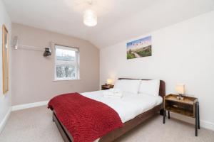 a bedroom with a large bed with a red blanket at Modern Maisonette in Vibrant Bristol, Free Parking in Bristol