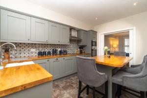 a kitchen with white cabinets and a wooden counter top at Modern Maisonette in Vibrant Bristol, Free Parking in Bristol