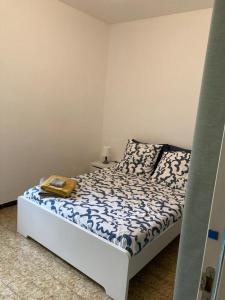 Schlafzimmer mit einem Bett mit einer blauen und weißen Bettdecke in der Unterkunft Joli appartement dans le centre ville de Corte in Corte