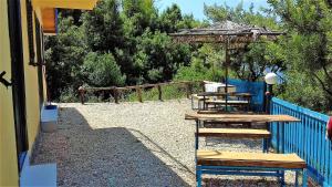 un patio con mesa y sombrilla en Ramo's Hilltop Retreat with Kitchenette and Patio - 1st en Vlorë