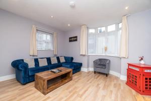 a living room with a blue couch and a table at Spacious 2 bed Southville flat near Harbourside in Bristol