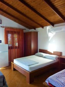 1 dormitorio con 2 camas y techo de madera en Ramo's Hilltop Retreat with Kitchenette and Patio - 1st en Vlorë