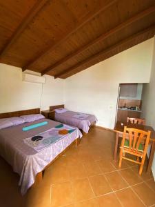 2 camas en una habitación con mesa y silla en Ramo's Hilltop Retreat with Kitchenette and Patio - 1st en Vlorë