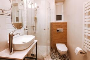 a white bathroom with a sink and a shower at Wawel Corner Apartment in Kraków