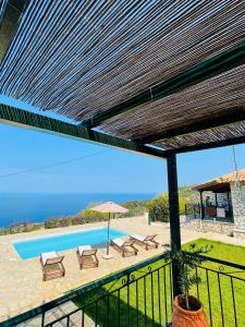 a view of a pool with chairs and an umbrella at Villa Aurora in Athanion