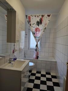 uma casa de banho com um lavatório e uma cortina de chuveiro em Käthe-Kollwitz-Straße 54, F2 em Altemburgo