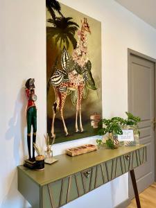 uma mesa com uma pintura de uma girafa em Coural' Chic em Narbona