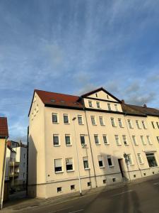 a large white building with a red roof at Käthe-Kollwitz-Straße 54, F2 in Altenburg