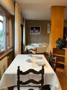 a dining room with two tables and chairs and a window at Belvedere da Cesarina in Tarvisio
