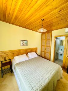 sypialnia z łóżkiem i drewnianym sufitem w obiekcie Villa Aurora w mieście Athanion