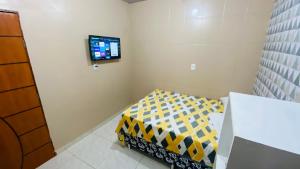 a room with a tv on the wall at Apartamento 3 Aconchegante São Jorge in Manaus