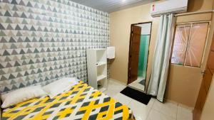 a small bedroom with a bed and a mirror at Apartamento 3 Aconchegante São Jorge in Manaus
